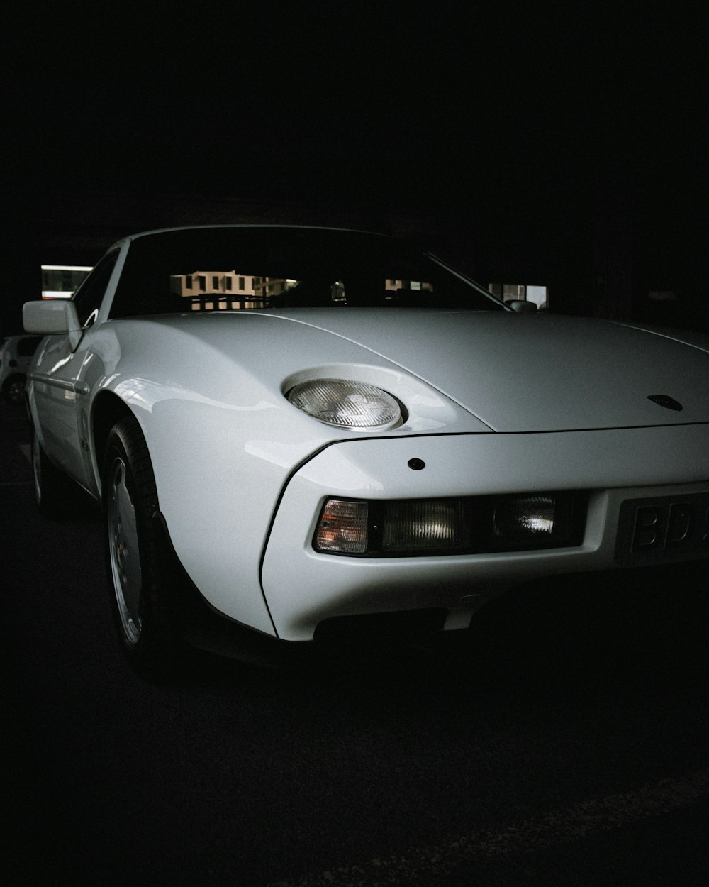 white porsche 911 parked on black asphalt road during night time