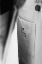 A close-up view of a fabric pocket with a label that reads 'ART CLUB'. The image is in black and white, with a focus on texture and contrast.