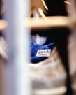 A clothing label with the text 'artclub and friends' is sewn onto a blue fabric. The image is focused on the label with blurred foreground and background, suggesting the photograph was taken in a clothing store or closet environment.