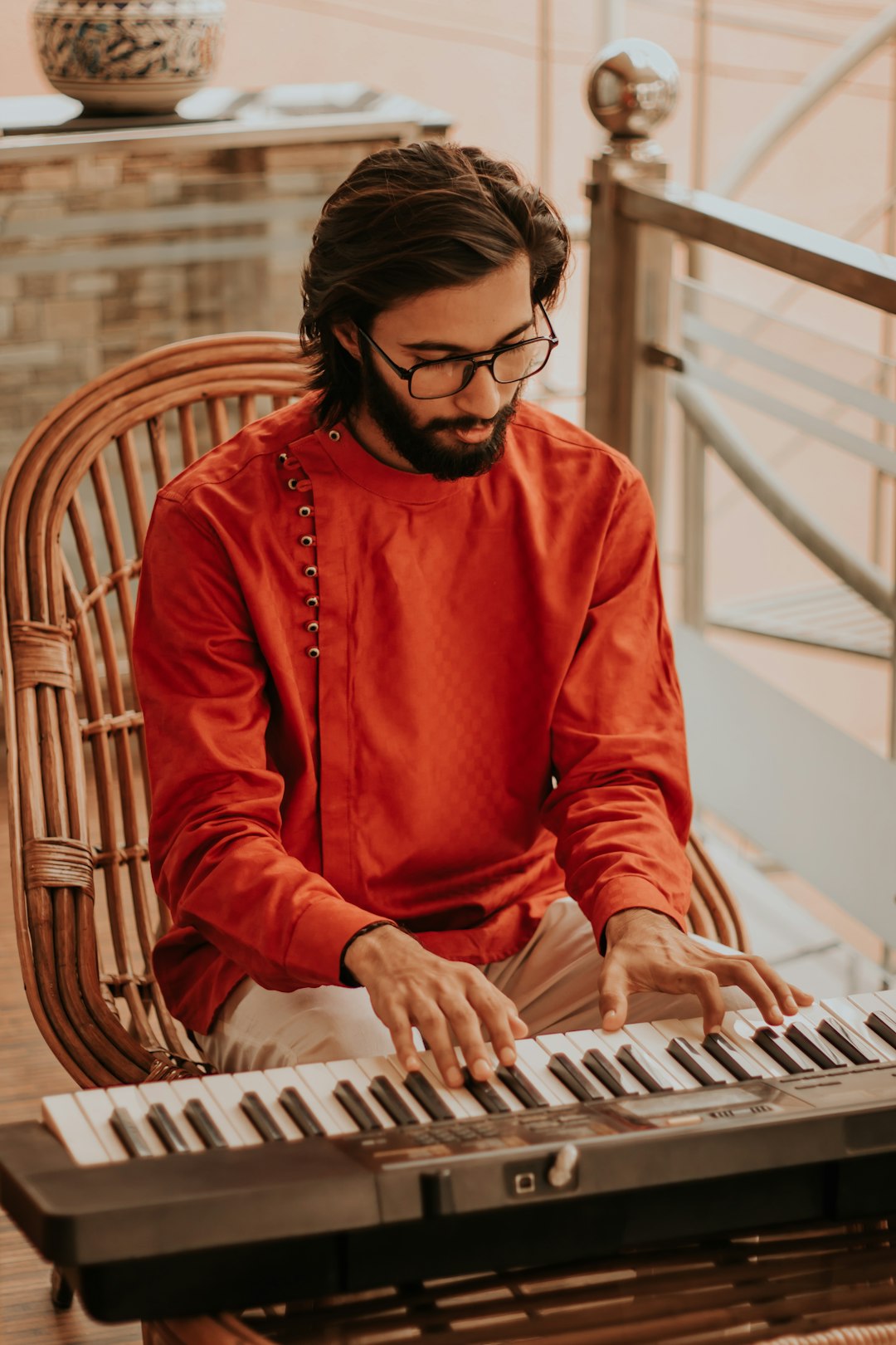 woman in orange long sleeve shirt sitting on brown wooden chair