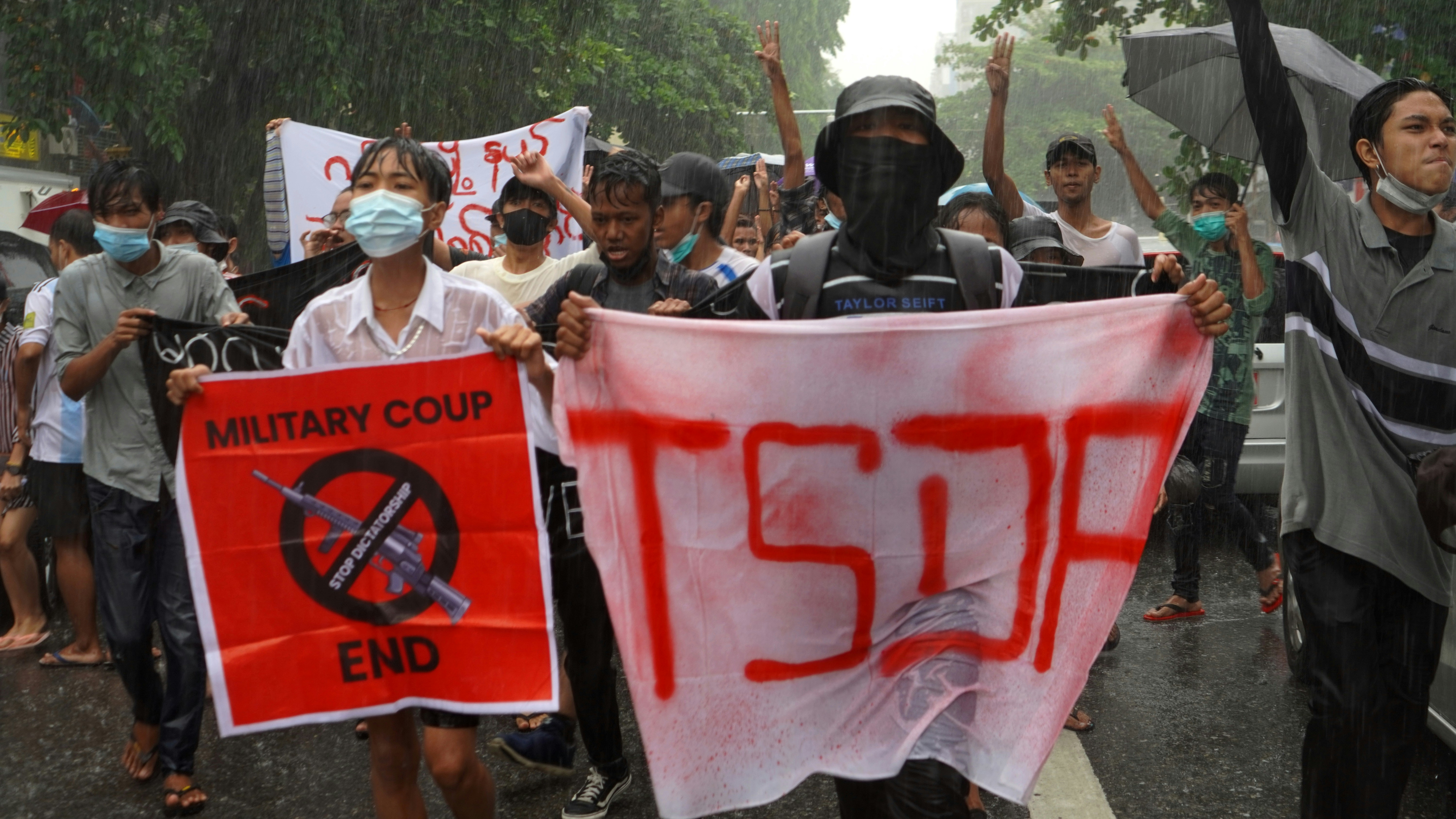 people in white and red shirt holding red and white banner during daytime