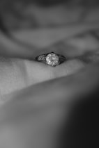 Close-up of a delicate gold ring with a sparkling diamond on a soft velvet surface.