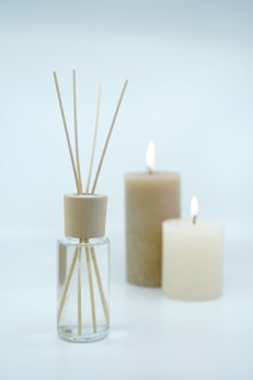 3 white pillar candles on glass bottles