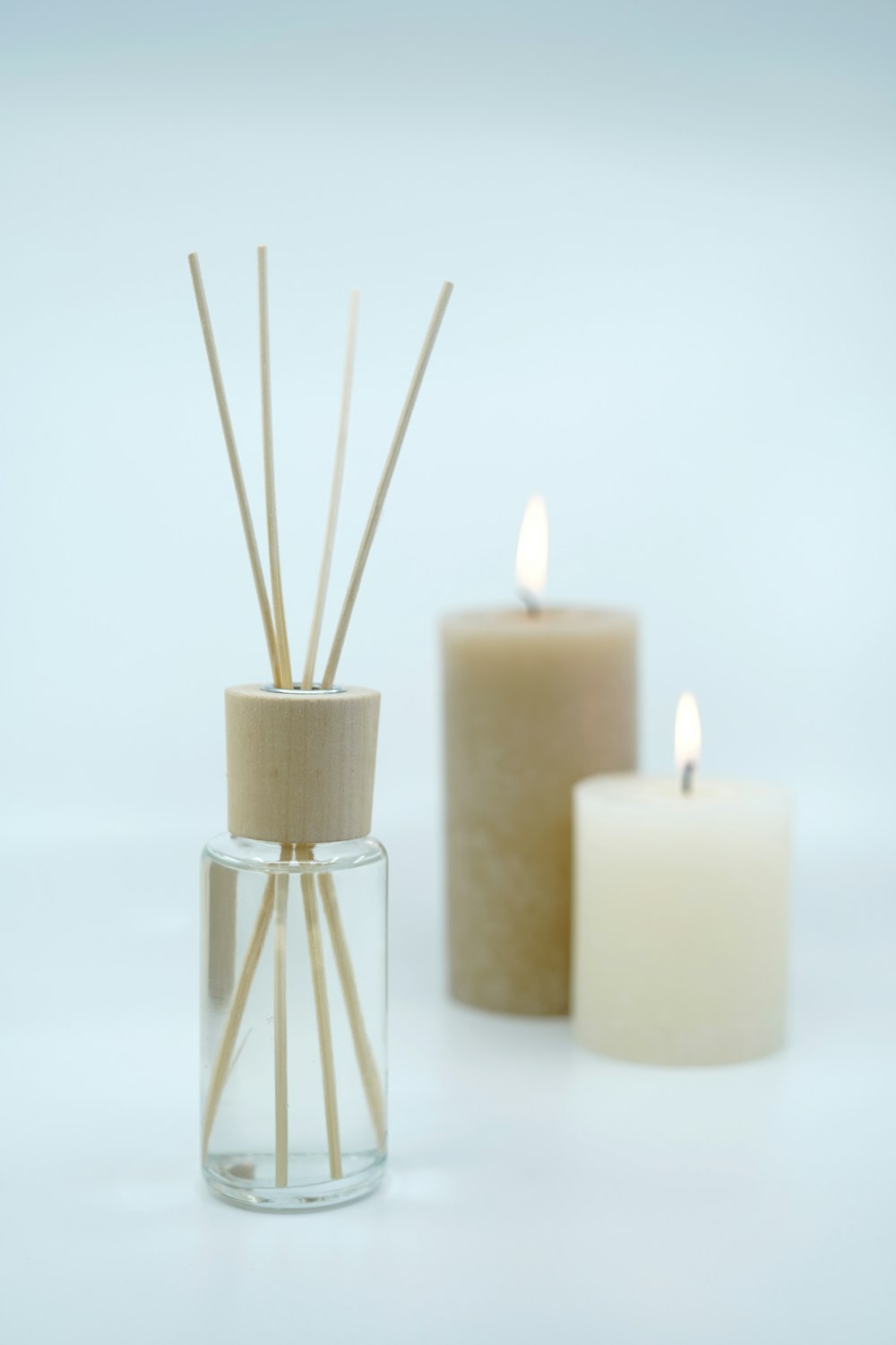 3 white pillar candles on glass bottles