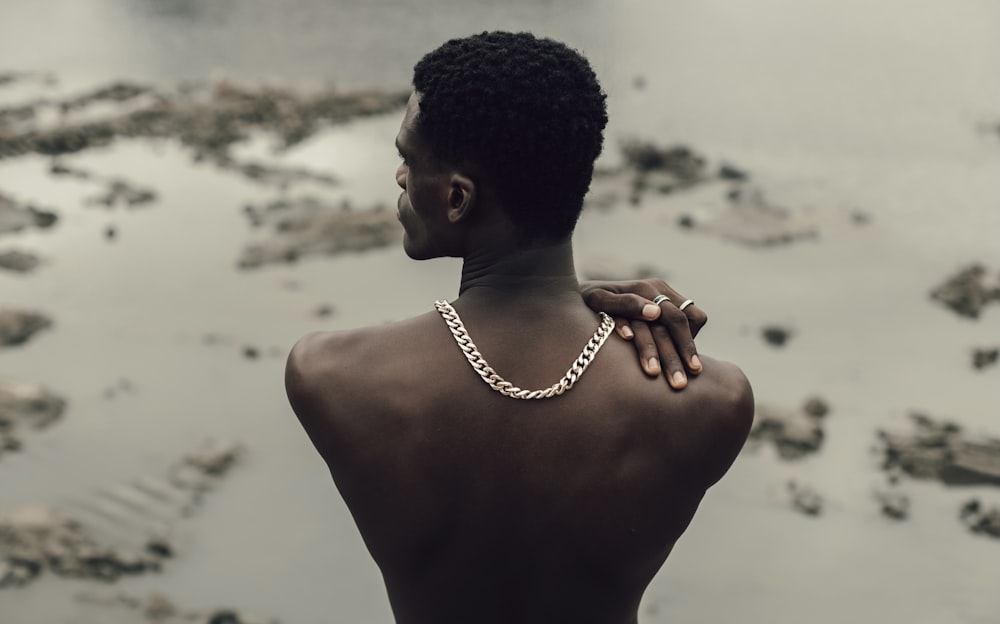 topless man wearing silver chain necklace
