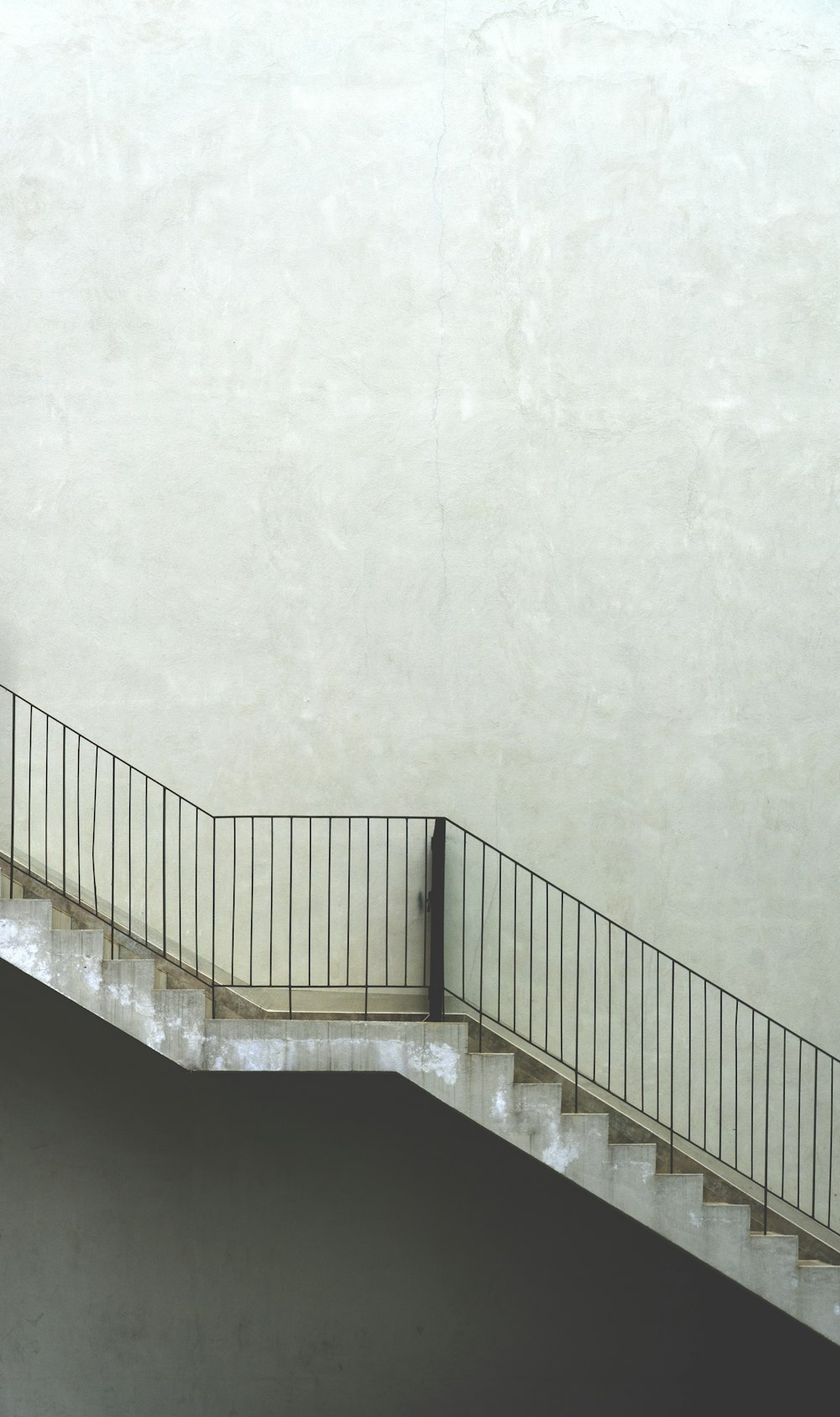 white concrete staircase with white wall