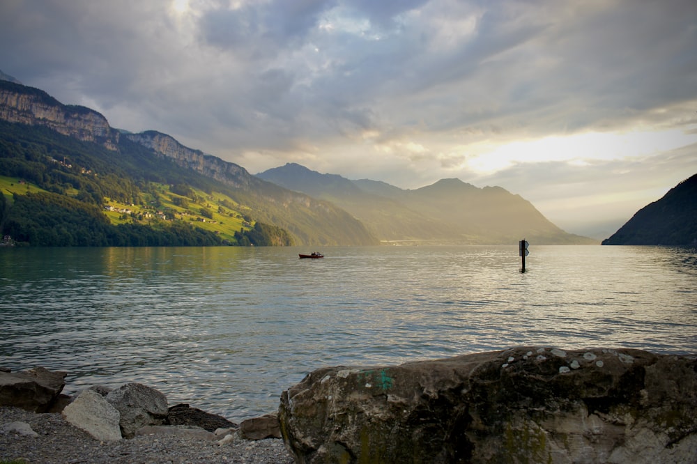 person standing on rock near body of water during daytime