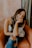 woman in white and black floral tank top and blue denim shorts sitting on brown couch