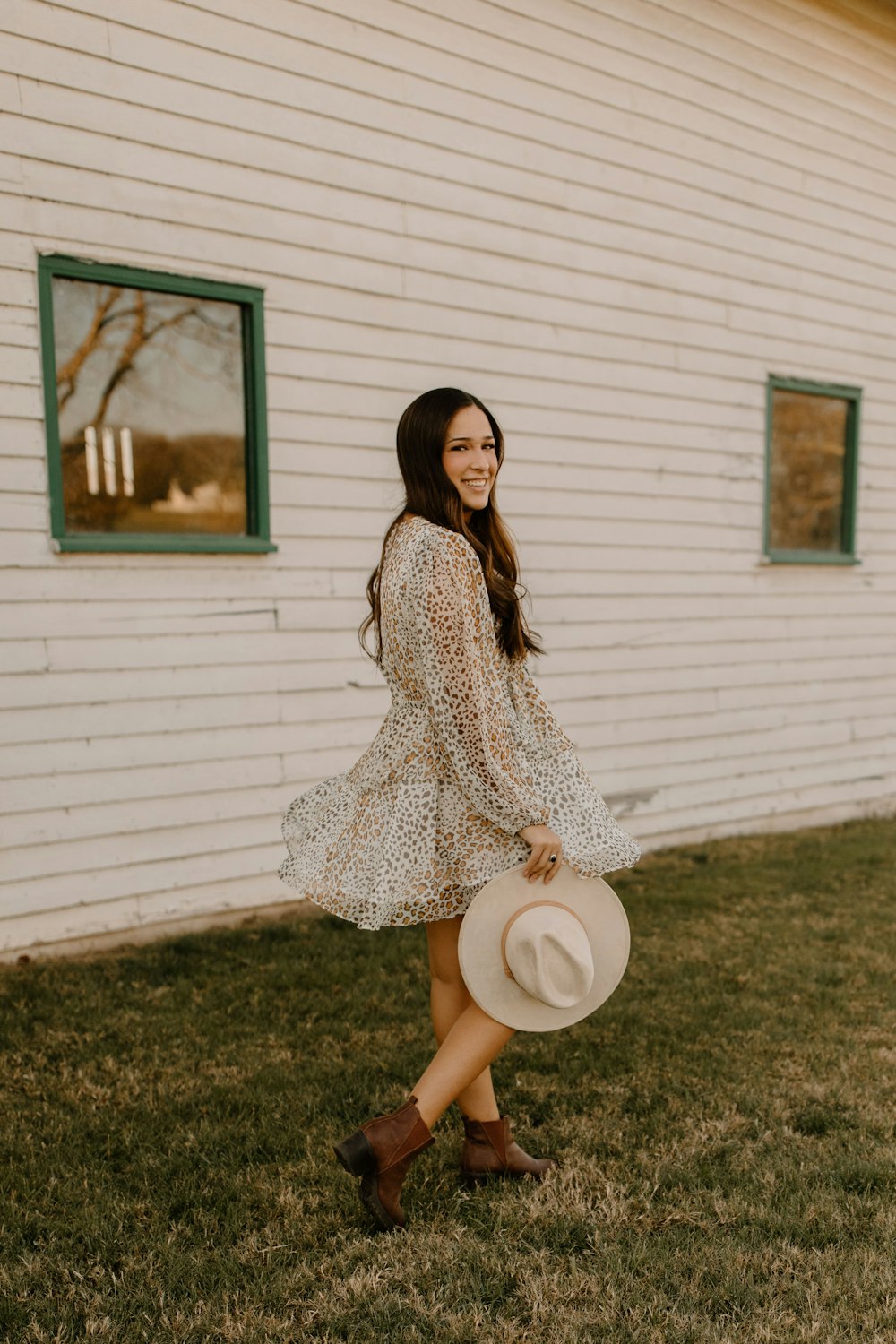 woman in white and black long sleeve dress holding white hat