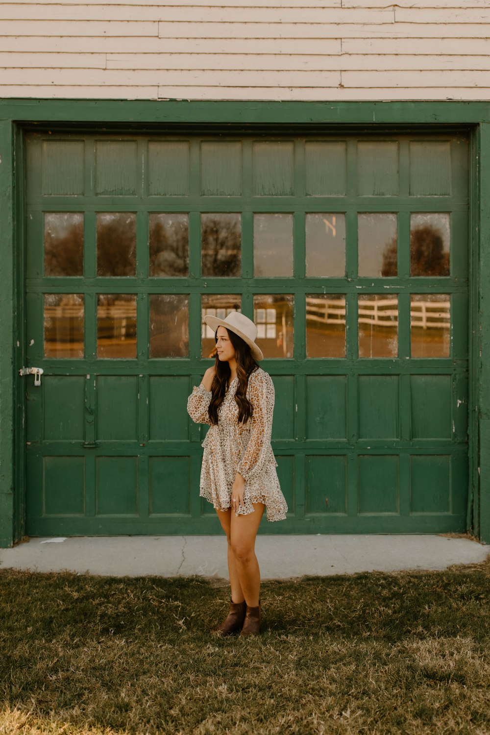 woman in white and black leopard print long sleeve dress standing in front of green wooden