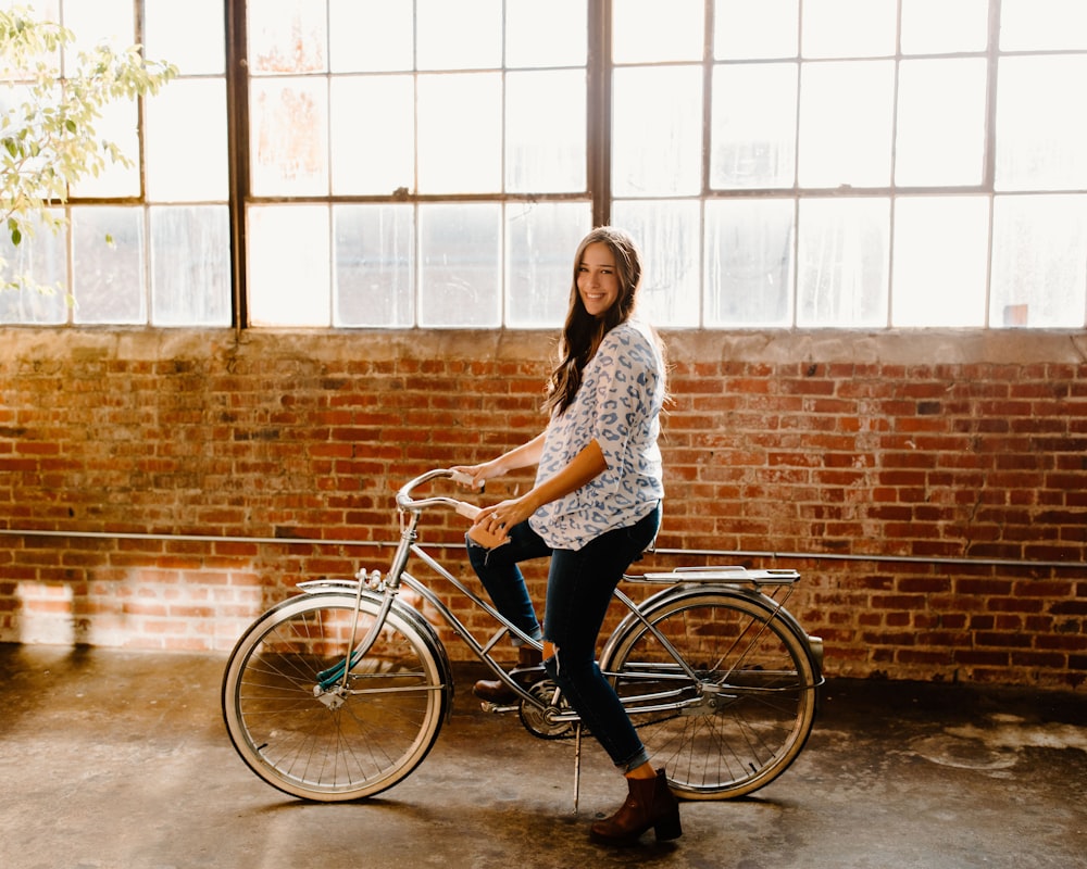 woman in white and black floral long sleeve shirt riding on bicycle