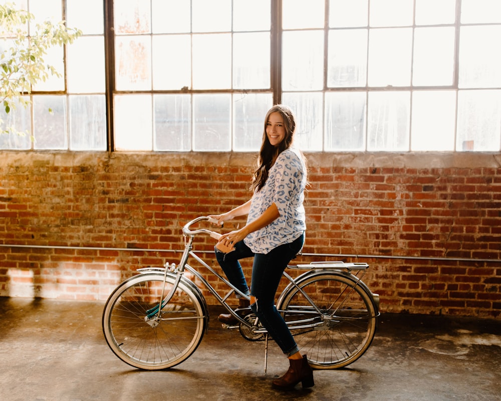 Mujer con camisa de manga larga floral blanca y negra montando en bicicleta