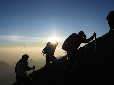silhouette of people on mountain during sunset