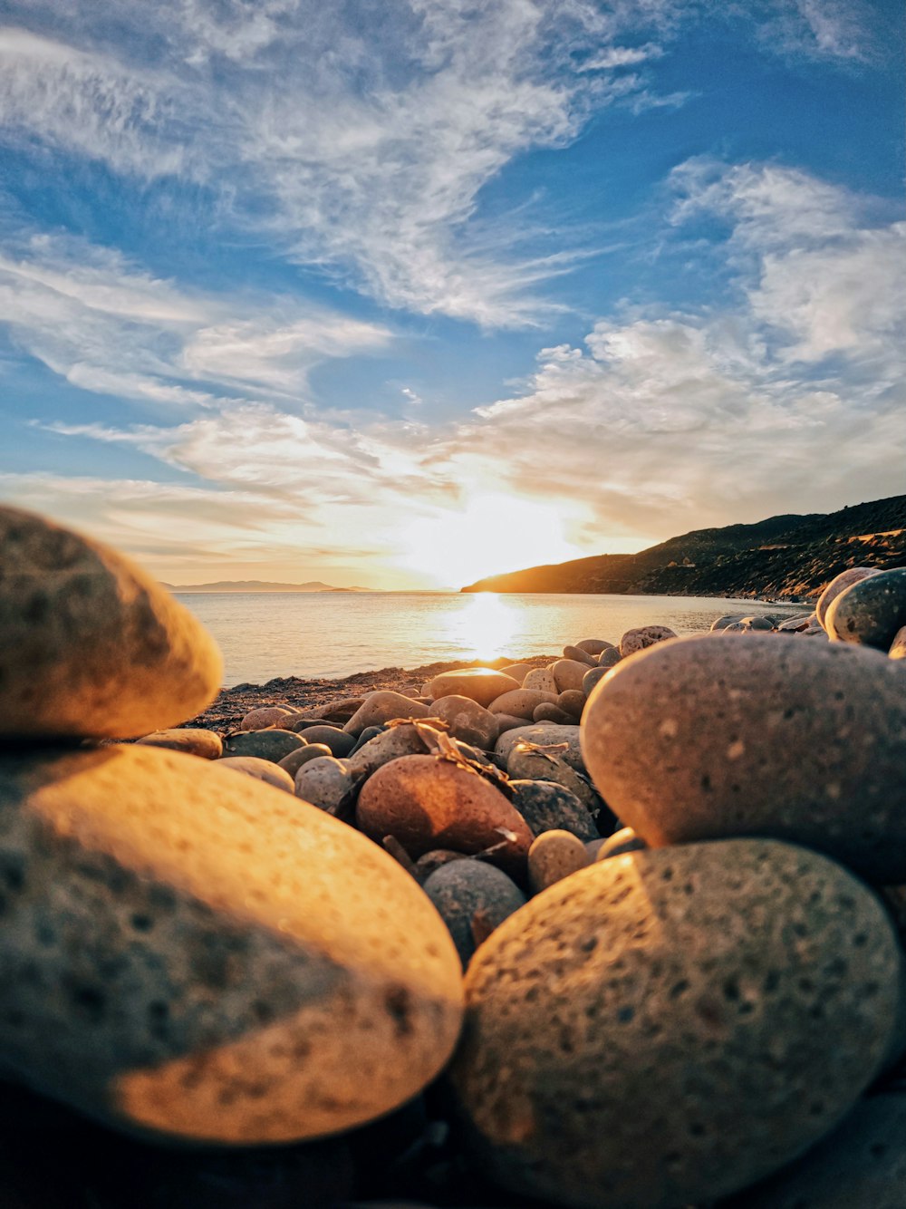 gray and black stones near body of water during daytime