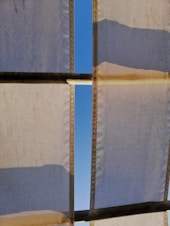 Finished canvas shades gracefully framing a modern storefront on a clear day.