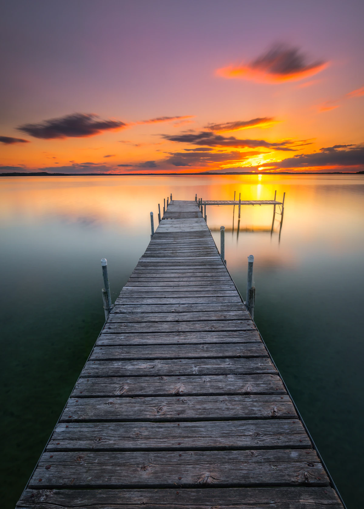 T-shape dock extending into calm Florida water at sunset