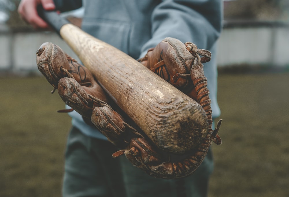 person in blue long sleeve shirt holding brown wooden stick