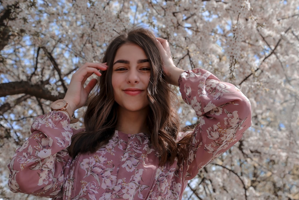 woman in pink and white floral long sleeve shirt smiling