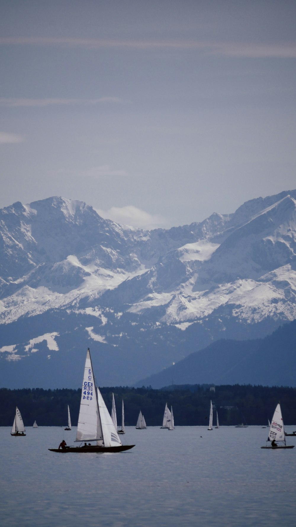 white sailboat on snow covered mountain during daytime