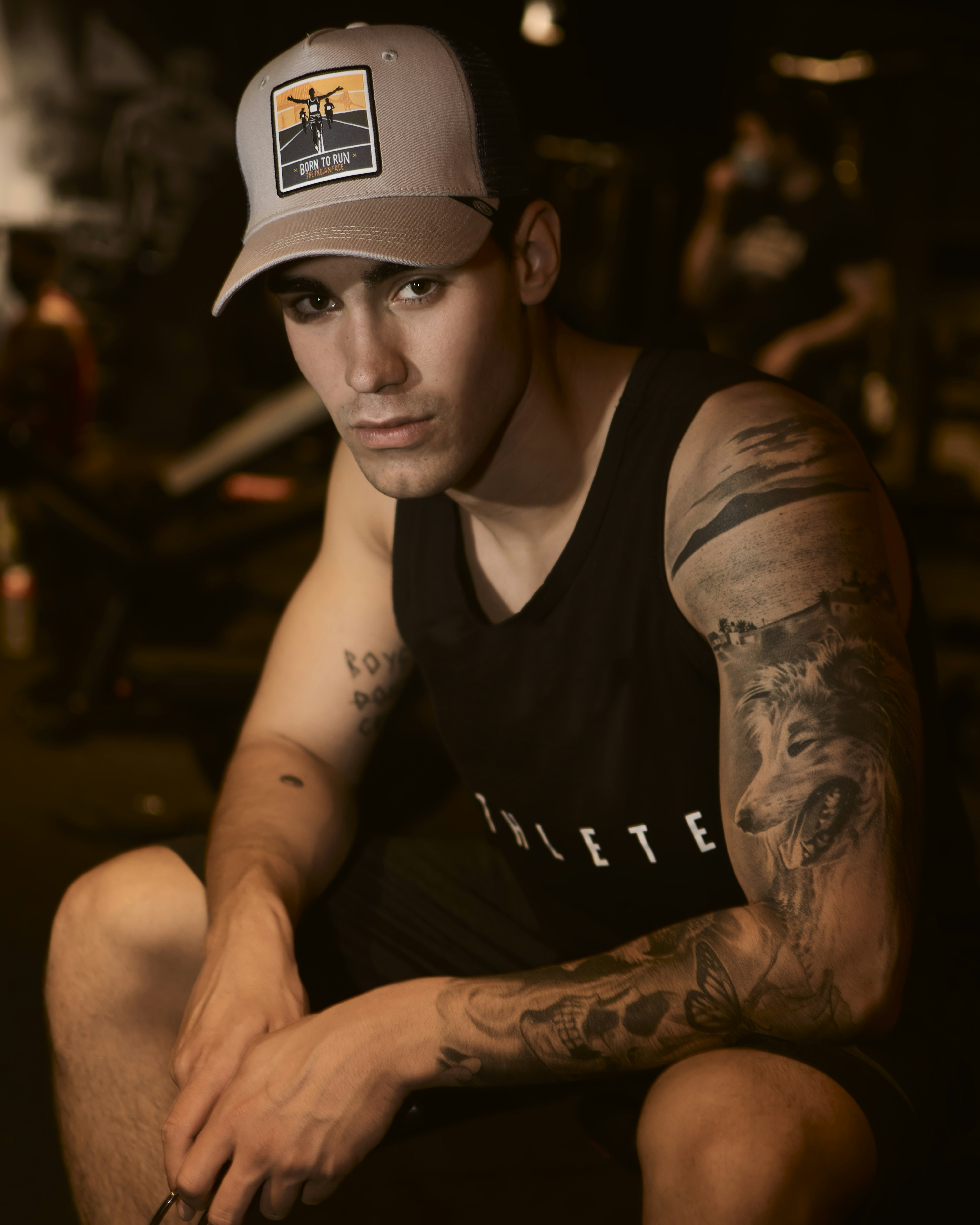 man in black tank top wearing white cap