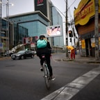 A compact cycling backpack strapped to a bike on a city street