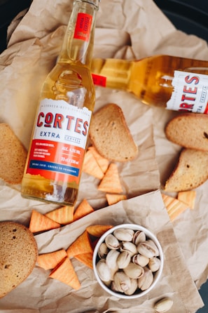 A hearty plate of mixed picadas featuring cured meats, cheeses, and olives with a cold beer glass