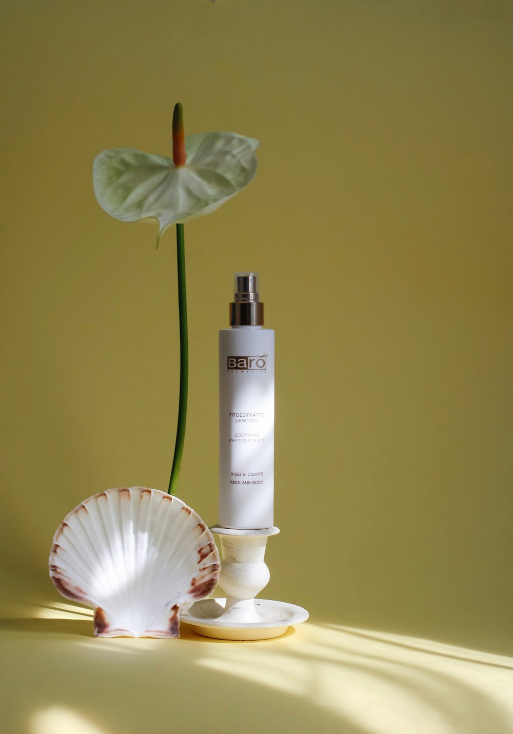 a bottle of lotion next to a flower