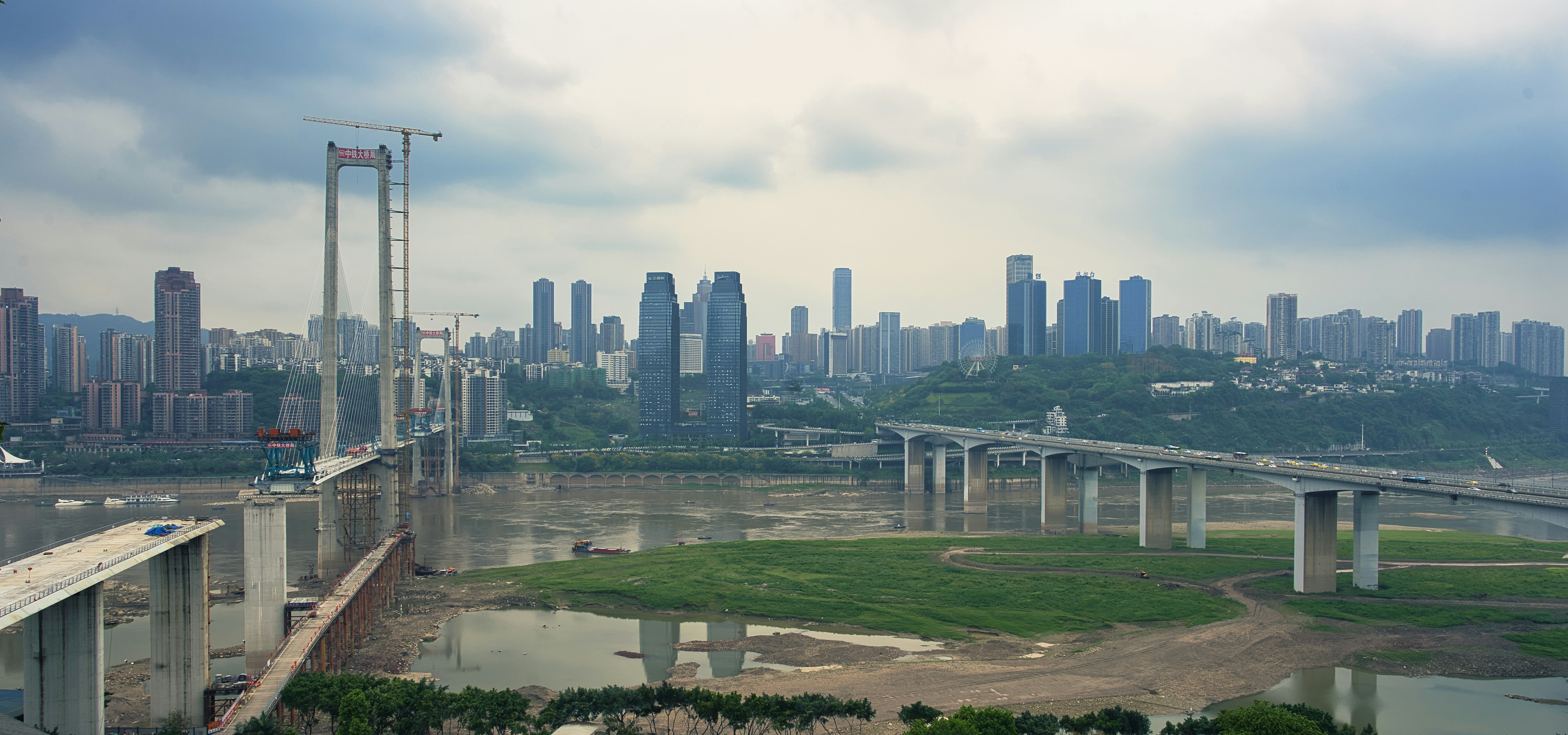 a bridge over a body of water with a city in the background
