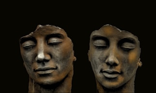 mans face carved on black surface