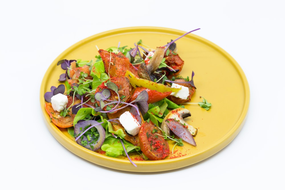 a yellow plate topped with a colorful salad