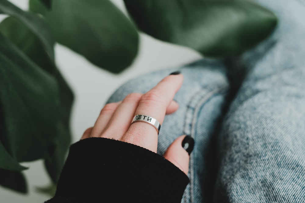 person wearing silver ring and blue denim jacket