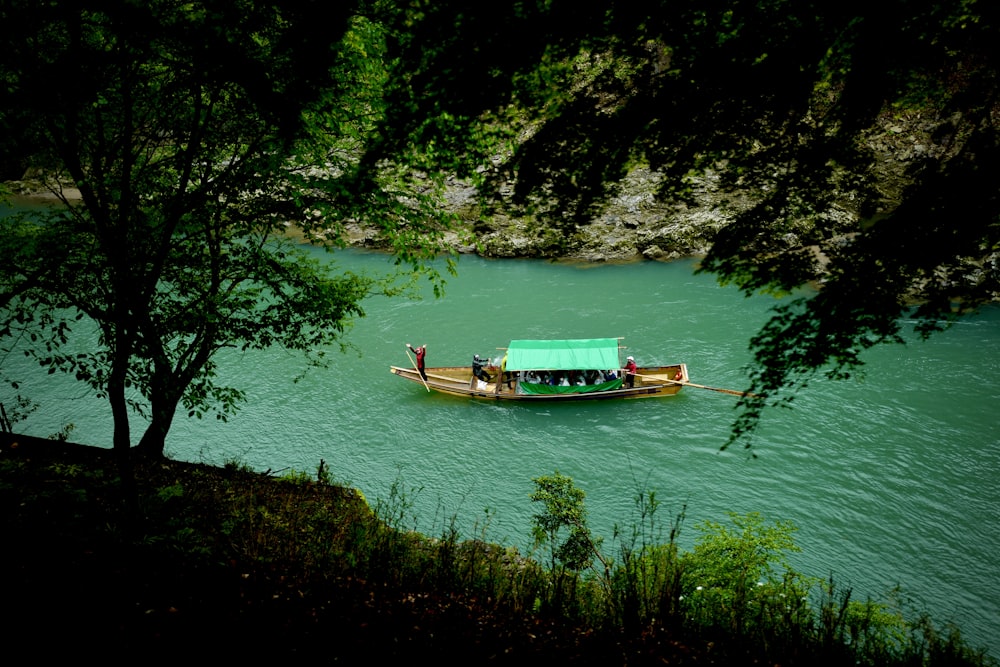 brown boat on body of water near green trees during daytime