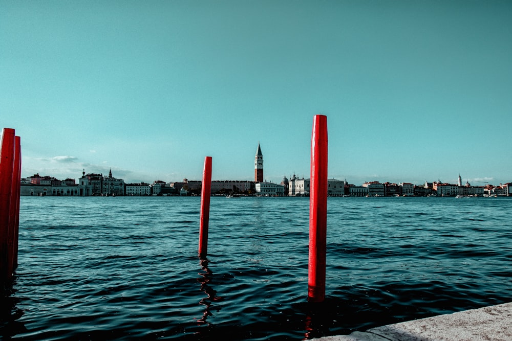 red metal poles on body of water during daytime