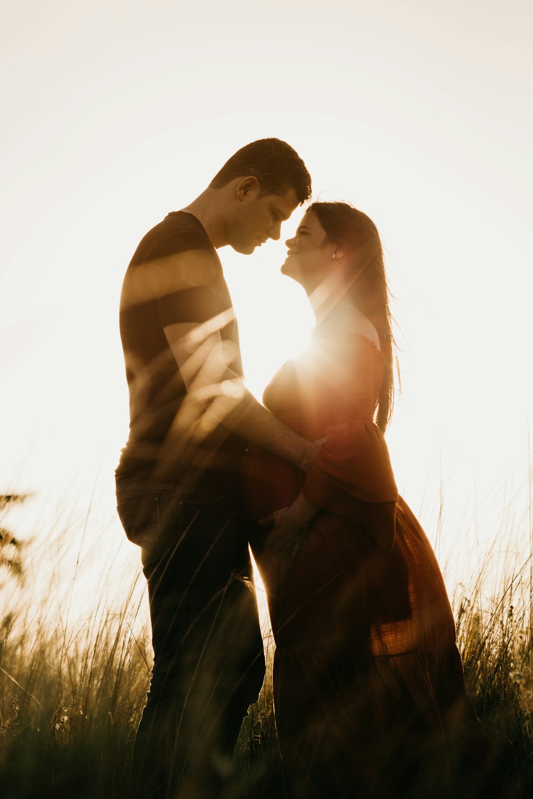 man in black shirt hugging woman in brown dress during daytime