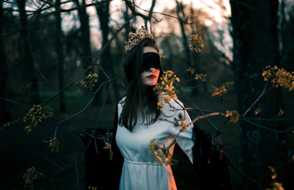 woman in white long sleeve dress standing near brown leaf tree during daytime