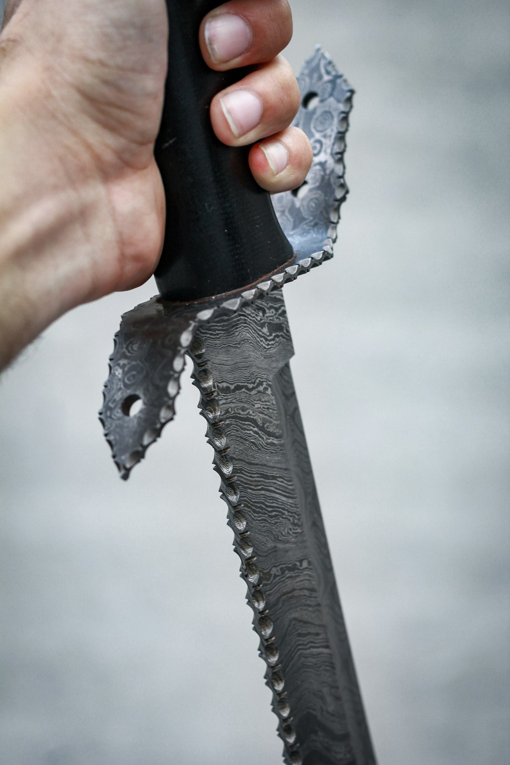 pessoa segurando faca de alça preta