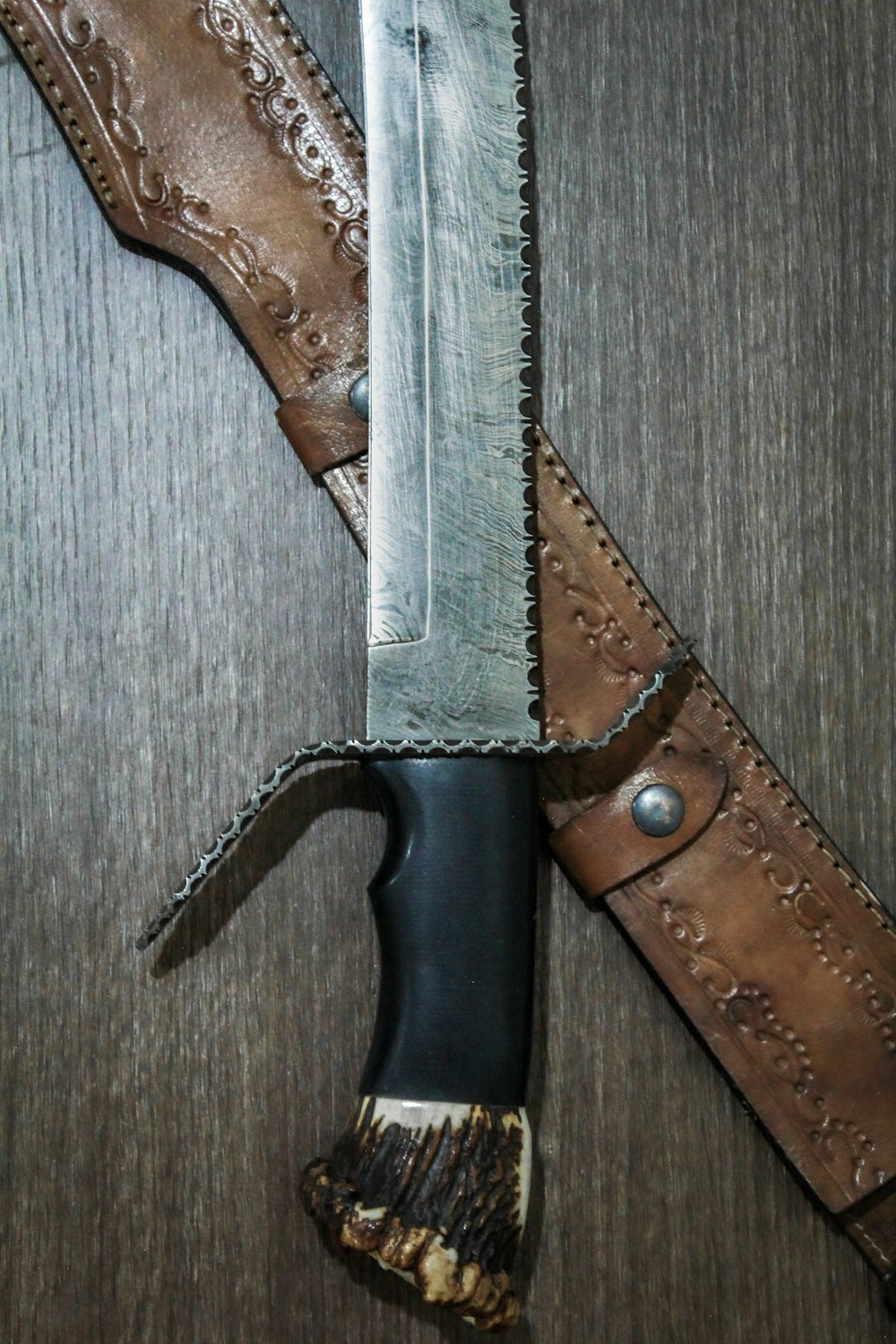 black and silver knife on gray wooden table