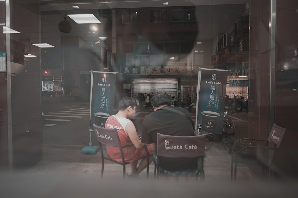 man in black jacket sitting on red chair