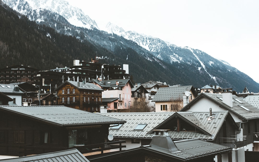 brown and white houses near snow covered mountain during daytime