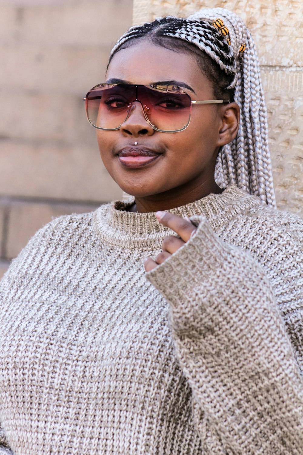 woman in white knit sweater wearing brown sunglasses