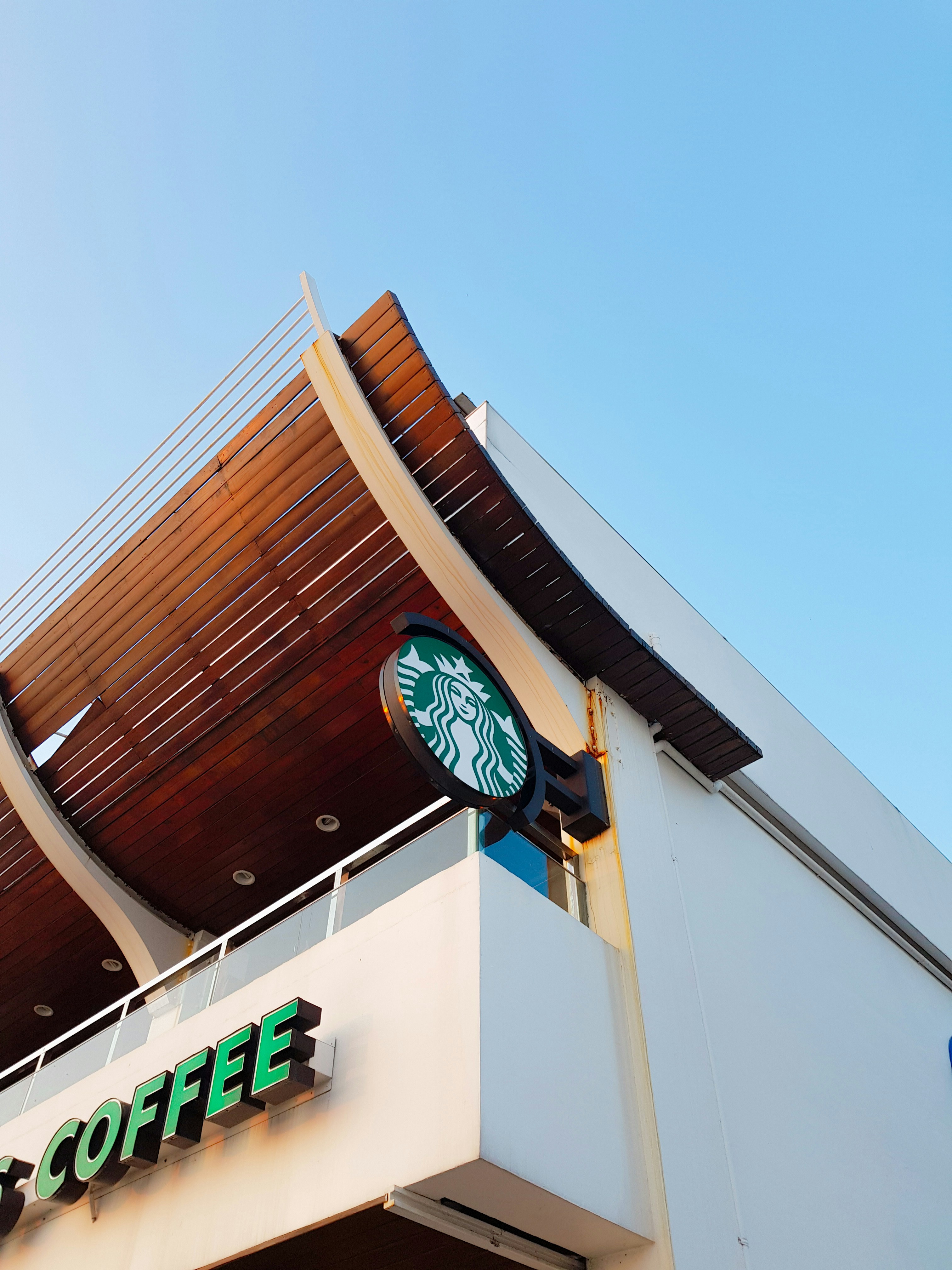 建物の側面にぶら下がっているスターバックスの看板の写真 – Unsplash