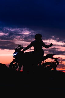 A sunset backdrop with a biker silhouetted against the sky.