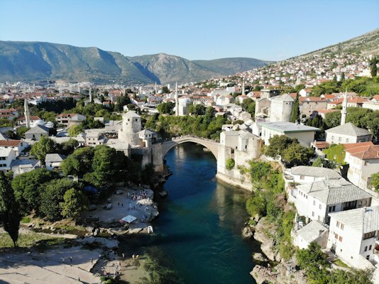 Aerial view of city buildings near body of water during daytime — Mostar, Bosnia and Herzegovina