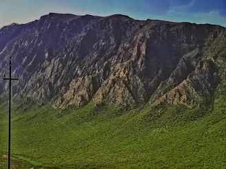 High-voltage power lines stretching across a mountainous landscape.