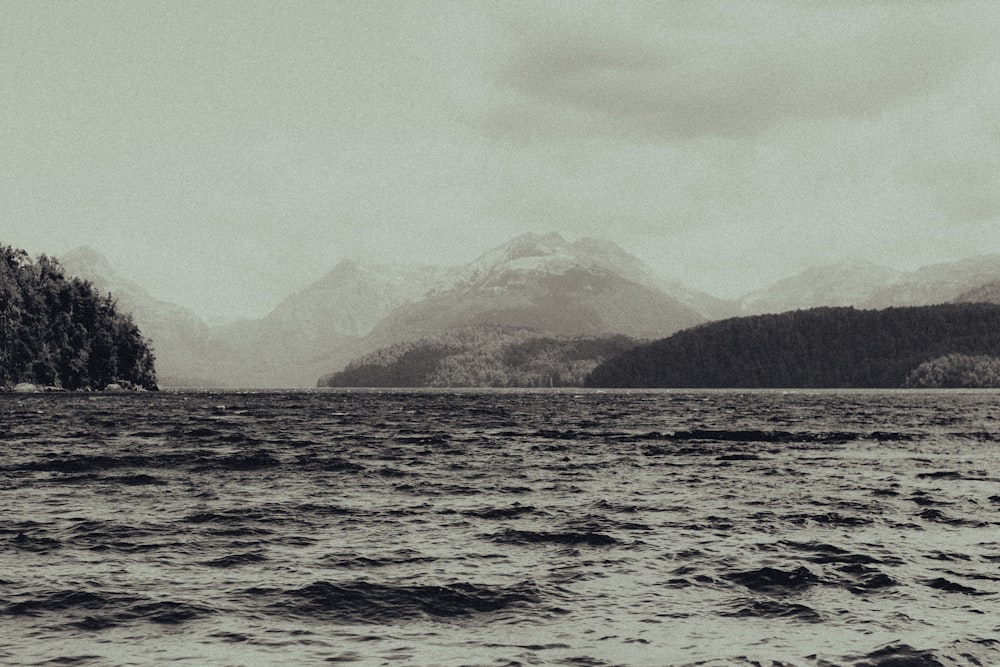 grayscale photo of mountain near body of water