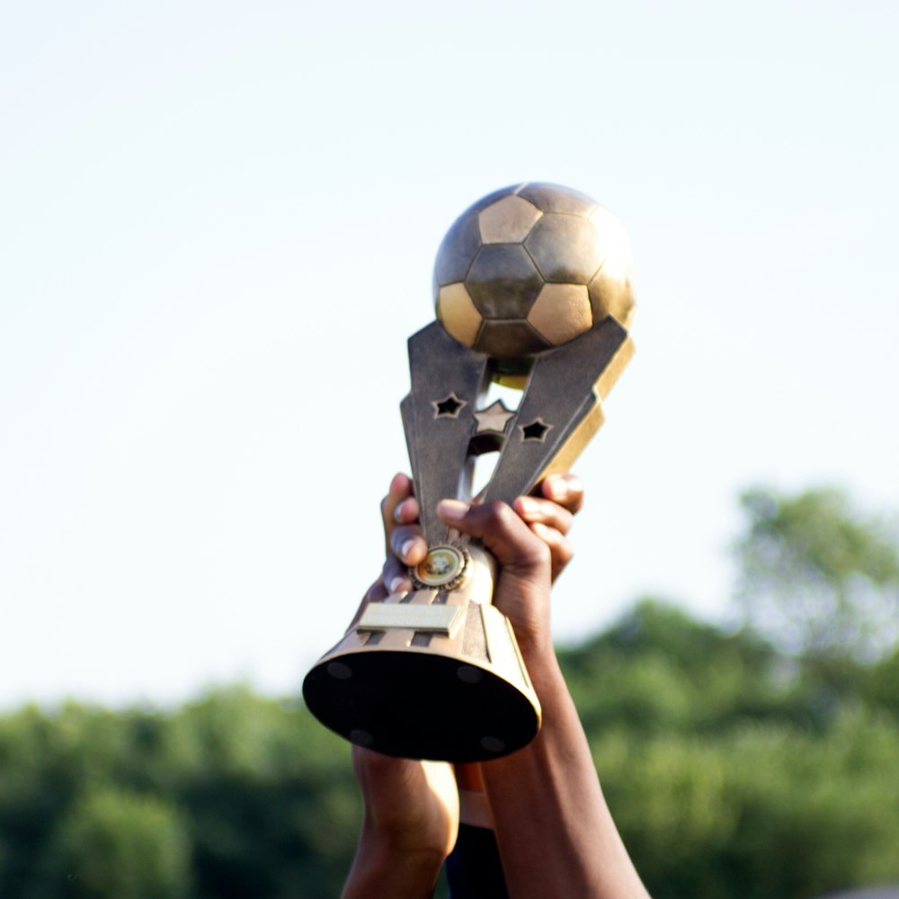 Persona che tiene il pallone da calcio bianco e nero