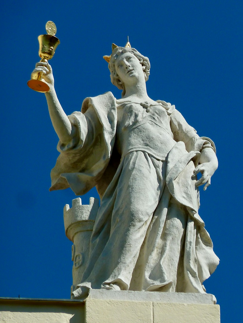 angel holding cross statue during daytime
