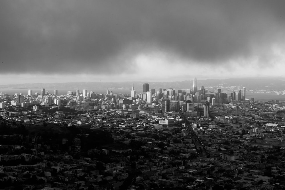 grayscale photo of city buildings under cloudy sky