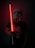 A person wearing a helmet holds a glowing red lightsaber in a dimly lit setting, with a shirt featuring a cartoon character.