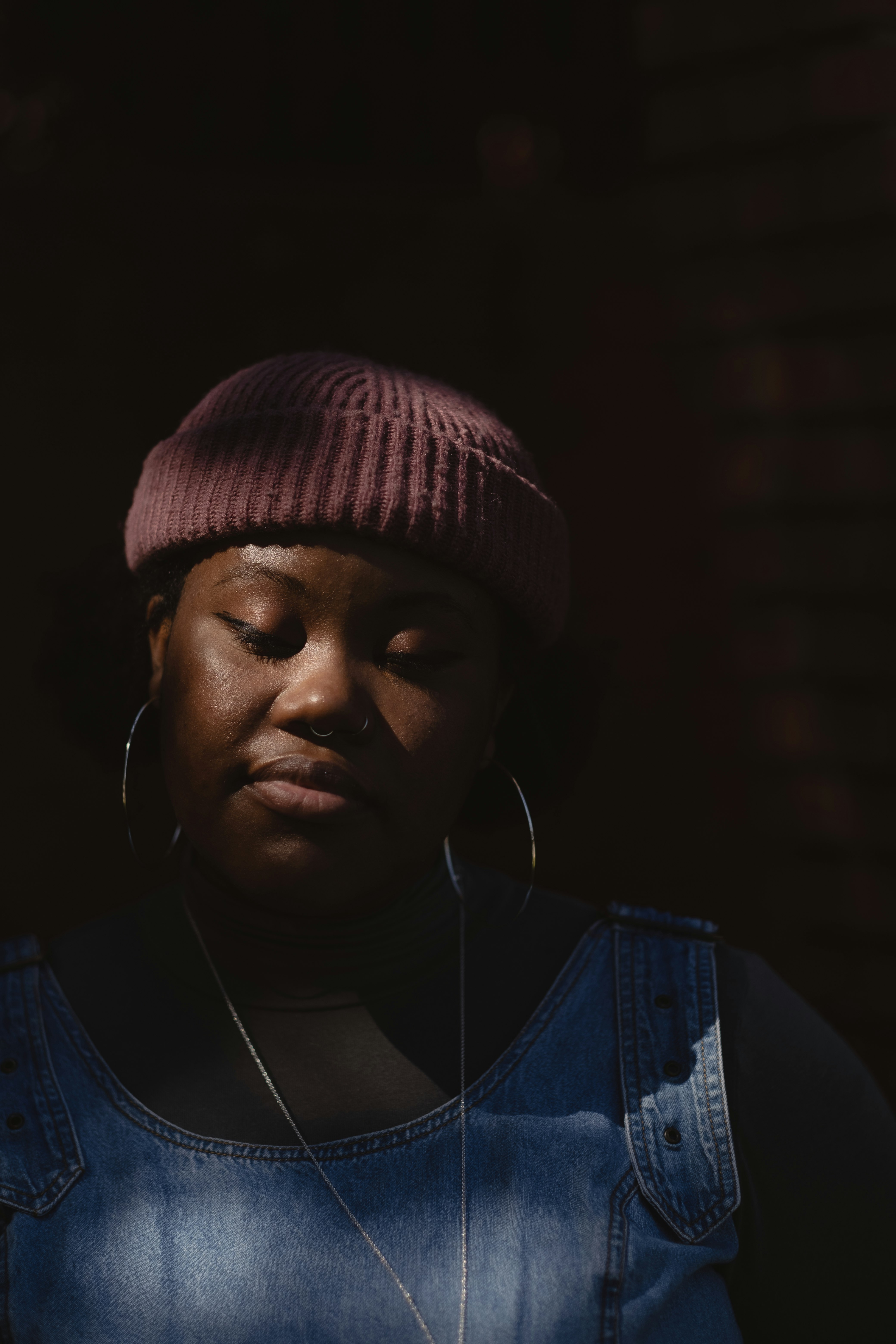 woman in blue denim jacket wearing white earbuds